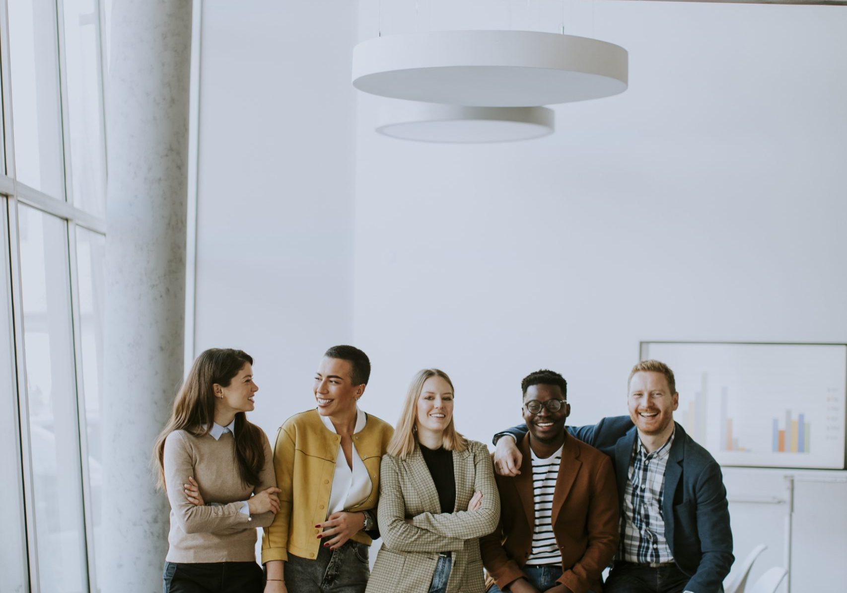 Group of positive businesspeople standing together in the office