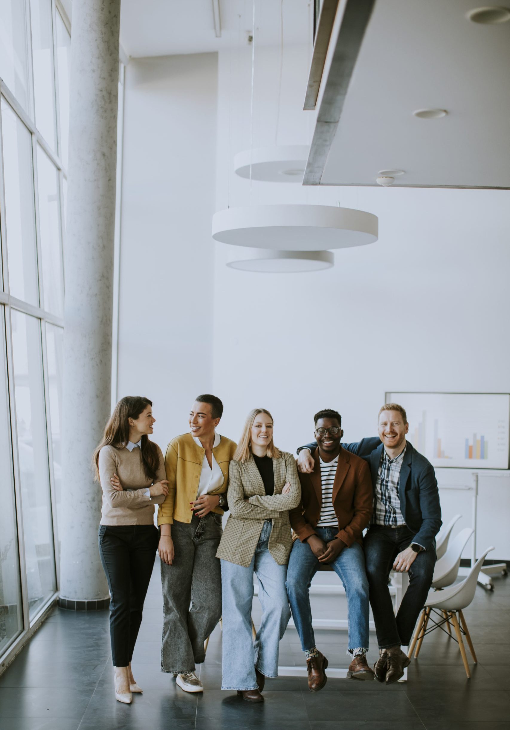 Group of positive businesspeople standing together in the office